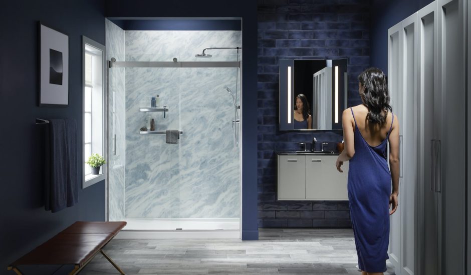 Woman entering bathroom with Bluette LuxStone shower walls